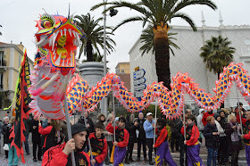 Pic of dancers holding dragon above their heads with sticks in carnival