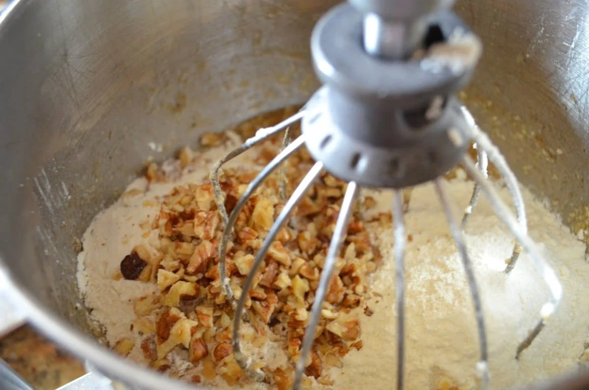 Banana Nut Muffin in a mixing bowl with mashed bananas, nuts and flour.