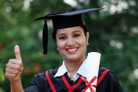 A smiling young woman wearing a black graduation dress and hat, asking how she can get an accredited high school diploma that you need