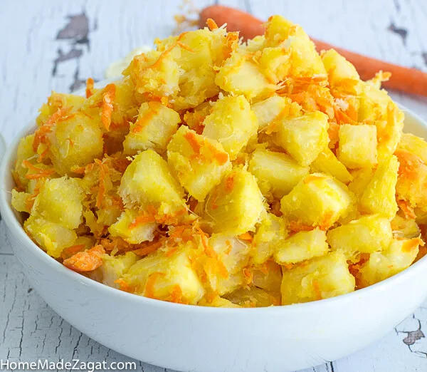 A white bowl of Cassava salad with carrots