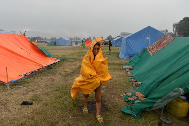 PHOTO: A woman battles a downpour at a relief camp for earthquake survivors in Kathmandu. (AFP: Ishara S. Kodikara)