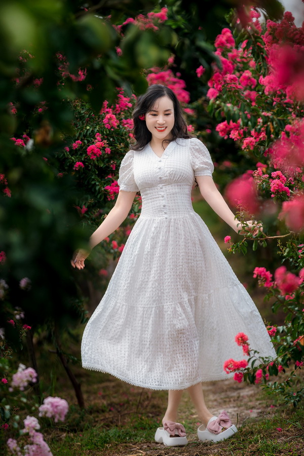 Thiếu nữ áo đầm trắng và hoa tường vi
