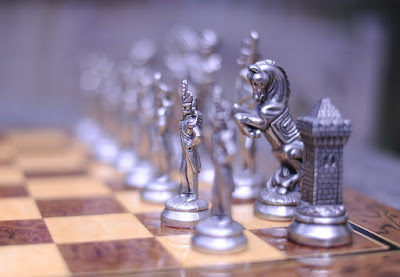 Chessmen on a chessboard with only a pawn and a knight in focus