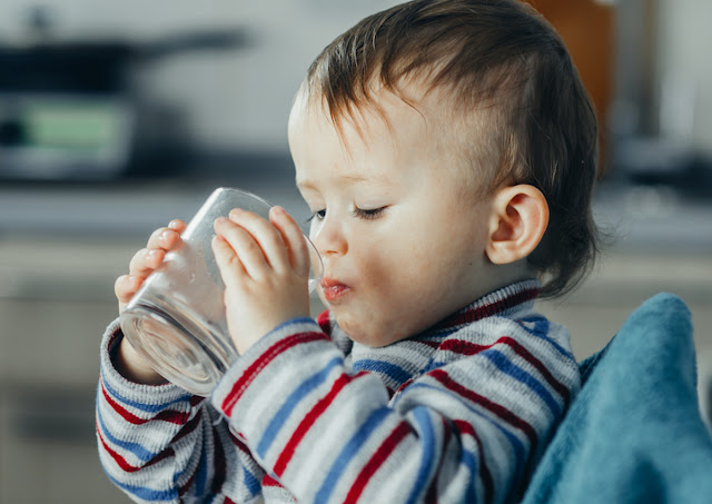 a little boy is drinking water