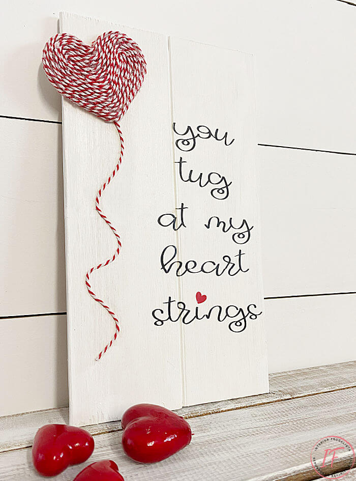 A quick and easy DIY scrap wood sign idea for valentine's day with an adorable heartstring quote that costs next to nothing to make.
