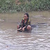 Photo: What in the world is this woman doing inside such dirty water?
