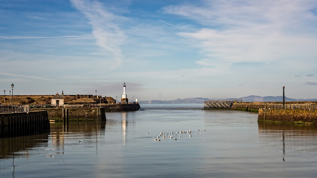 Photo of Maryport lighthouse reflected in the flat, calm water on Tuesday