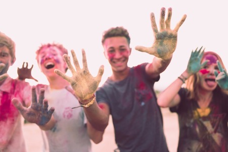 happy teenagers covered in coloured substance