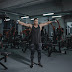 Man lifting dumbbells inside a gym