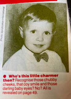 It's a photo of a small boy, and the captain says, 'Who's this little charmer then? Recognise those chubby cheeks, that coy smile and those darling baby eyes? No? All is revealed on page 49.'