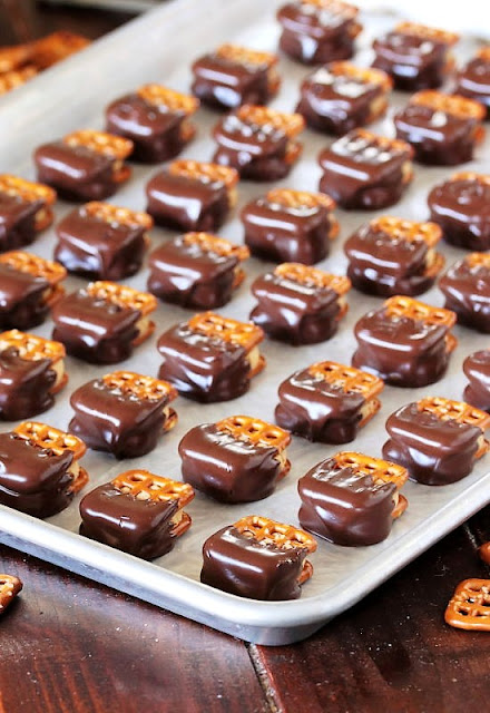 Peanut Butter Buckeye Pretzels Coated in Chocolate Laid Out in Rows on a Baking Sheet Image