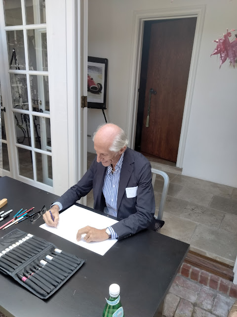 Auto designer Maurizio Corbi sketching a car at the Ferrari Club of America's 60th Anniversary party