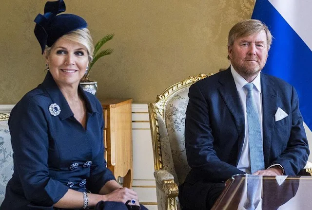 Queen Maxima's outfit, navy coat and dress, is from the fashion house Natan. Philip Treacy. President Zuzana Caputova