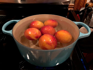 image of six peaches in a pot of boiling water