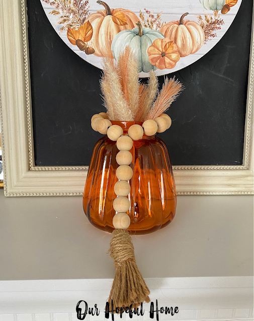 amber jar with mini wood bead garland and floral picks