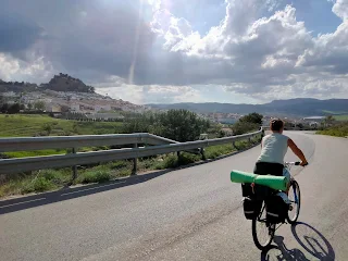 Aim'jie on her bike, a village in the background.