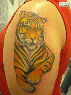 Tigre tatuado no braço.