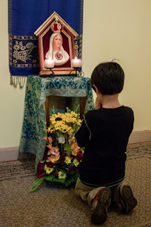 Jongentje bidt bij het oratorium van de Herauten van het Evangelie