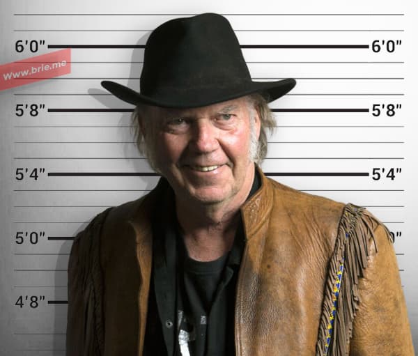 Neil Young standing in front of a height chart