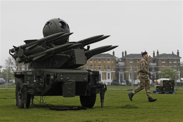 A soldier runs past a Rapier missile defence battery deployed at Blackheath Common in London