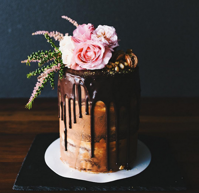 delicious-naked-cake-with-chocolate-poured-from-top-and-peanuts-sprinkle-with-roses-topper