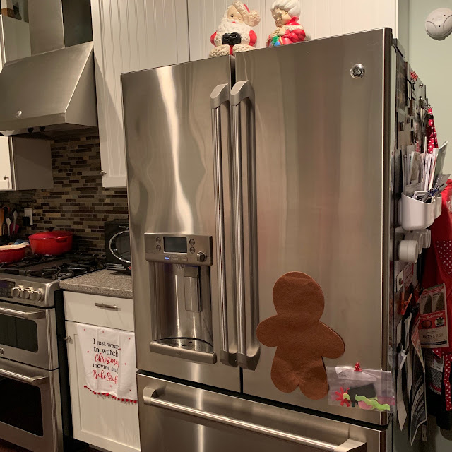 A photo of a kitchen, with Christmas decorations and a gingerbread man activity on the refrigerator