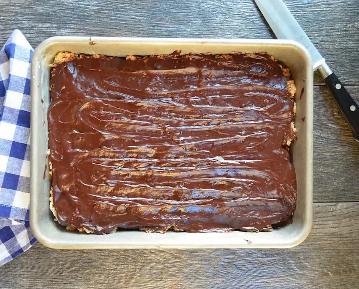 A down shot of Brown Butter Rice Krispy Treats covered with Chocolate Ganache in a 9"x13" metal pan.