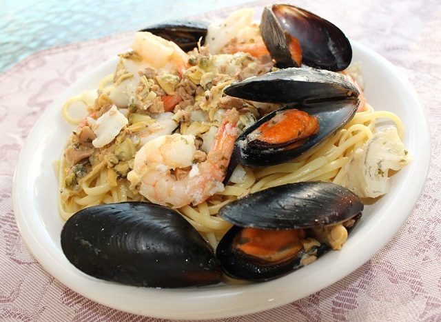 this is a medley of mussels and other seafood on top of pasta