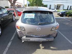 Dented tailgate & bumper on Mazda 3 before auto body repairs & paint at Almost Everything Auto Body
