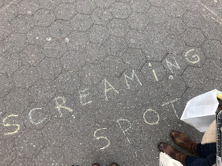 A patch of sidewalk that says in chalk, "Screaming Spot."