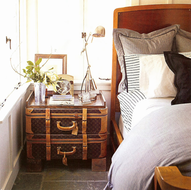 Bedroom with two Louis Vuitton trunks doubling as a nightstand