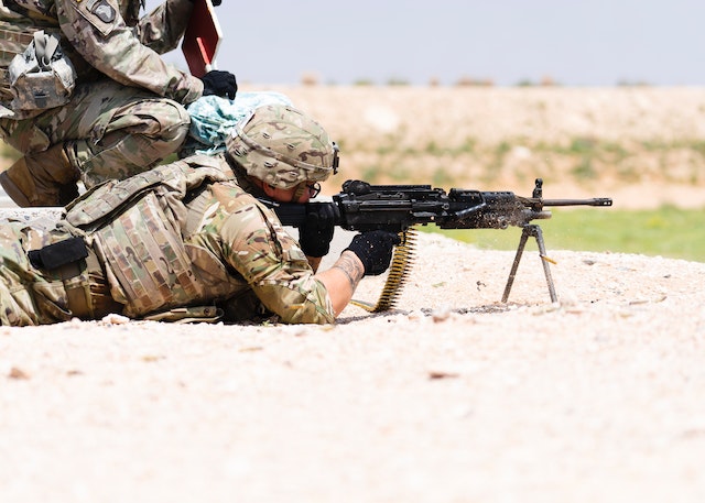 A soldier lying down, ready to fire his gun.
