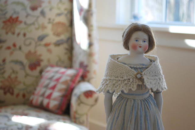antique china doll with knitted shawl