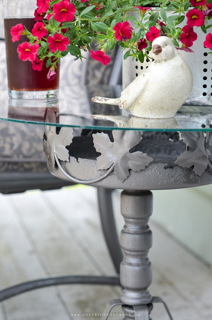 A rusty plant stand gets a second life as an outdoor accent table.  See the before and after at www.andersonandgrant.com #DIY #repurposed #DIYtable