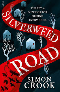 Cover for book Silverweed Road by Simon Crook. A winding, blood red road alongside which are white skeletal trees and white, elemental houses. At the top, the words "There's a horror behind every door".