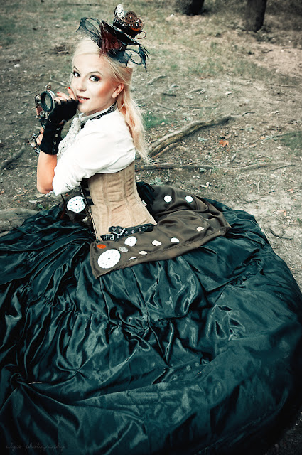 Woman wearing a steampunk satin skirt with corset blouse and hat/fascinator