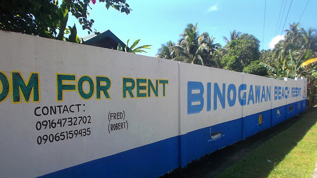 Binogawan Beach Resort contact numbers painted on their fence