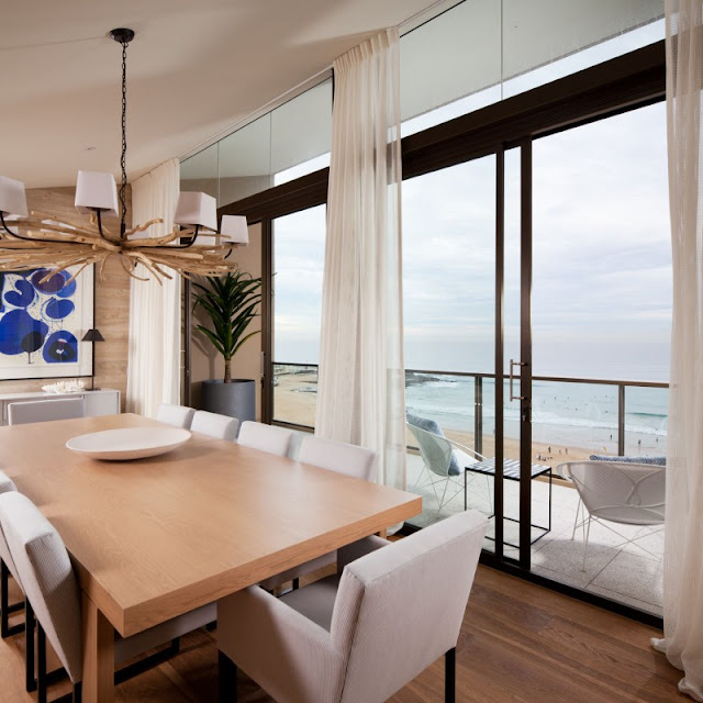 Photo of modern dining table by the balcony window with the view of the beach