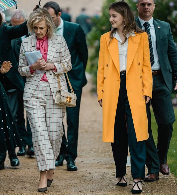 Crown Princess Elisabeth wore a yellow wool cashmere coat, and gold earrings. Zara trousers and silk shirt. Princess Astrid wore a suit