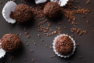 brigadeiros confeitados em um fundo escuro