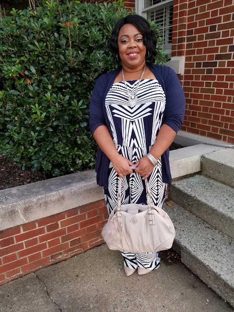 Curvy blogger wearing jumpsuit with cardigan, nude handbag and kitten heels, and silver accessories.