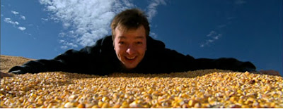 Photo of Curt Ellis atop a huge pile of corn, courtesy of King Corn