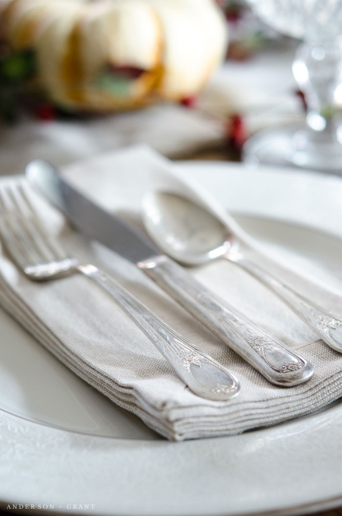 Antique silverware layered on a linen napkin.  |  www.andersonandgrant.com