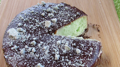 Peppermint cheesecake base on a chocolate graham cracker crust, covered in chocolate, sprinkled with mint chips for decoration
