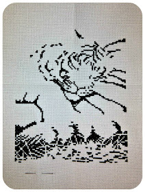 The black layer of a cross-stitch showing a tiger cub sleeping on his mother's tail.