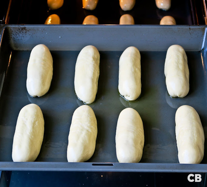 De mediterrane kipworstenbroodjes mogen een lauwe oven in om te rijzen