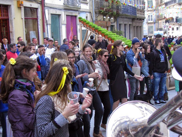 Pessoas dançando e instalação com vários vasos de manjerico na Rua das Flores