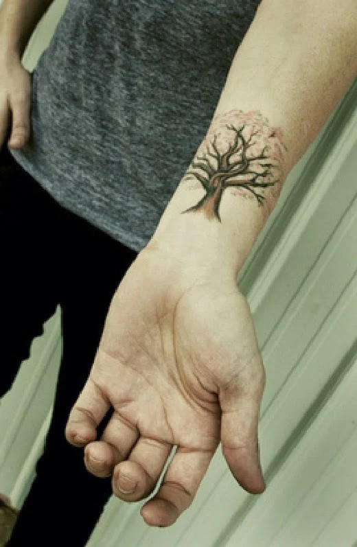 vemos a una chica que luce un tatuaje de arbol