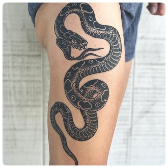 black-ink-snake-on-woman's-thigh-tattoo