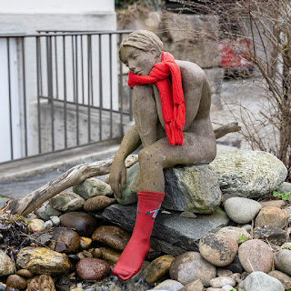Frauenskulptur mit rotem Halstuch und Strumpf in einem Garten in Wohlen AG.